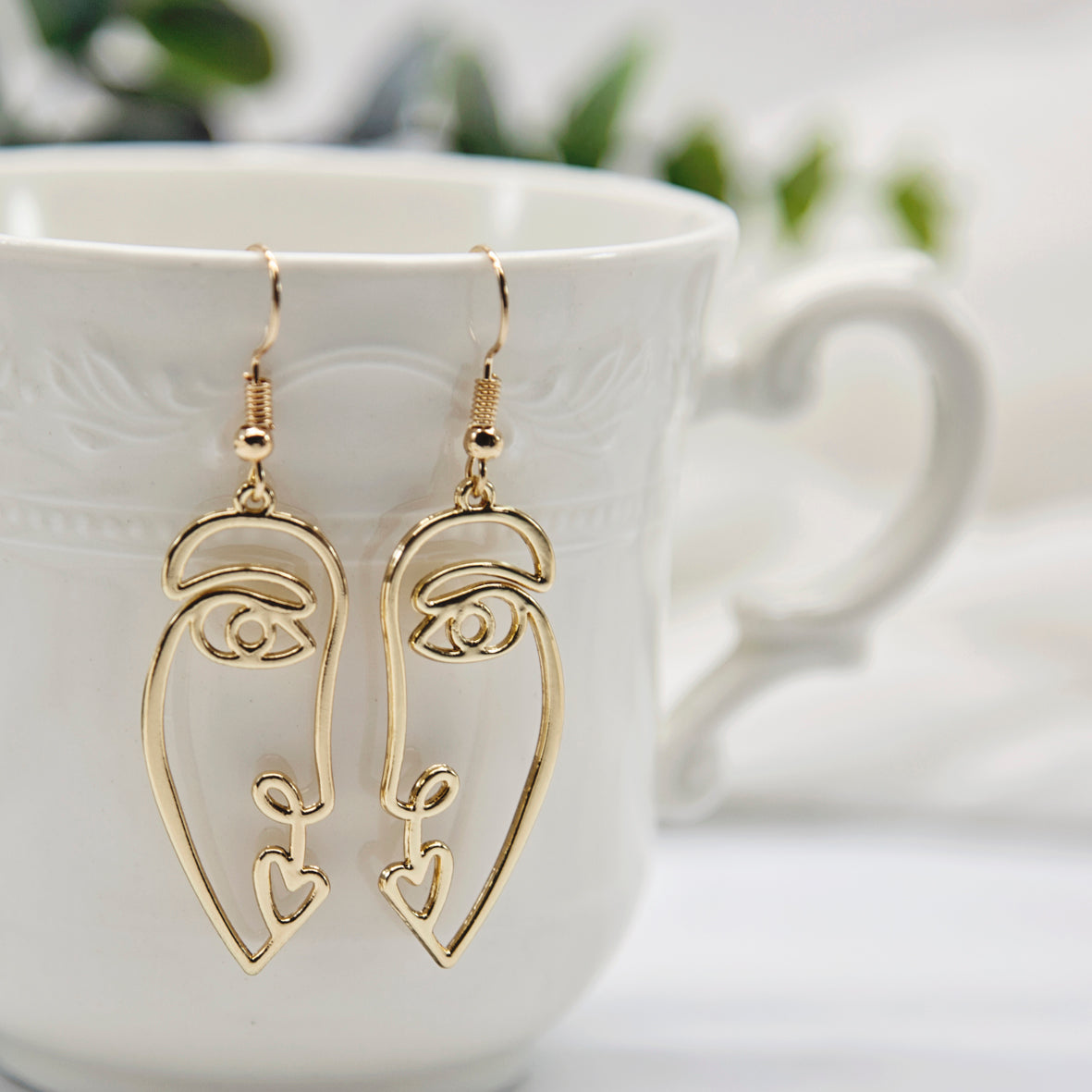 Gold face store earrings